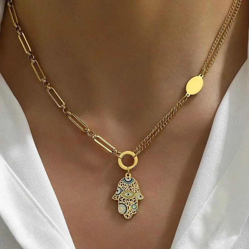 Descubra o Colar Mão De Fátima em Aço Inoxidável, com design Multicolorido e Dourado. Este Colar Feminino oferece Proteção e Estilo, sendo Resistente à Água, Durável e Hipoalergênico. Ideal para Festas e uso diário, combina Moda e Espiritualidade em uma peça única.