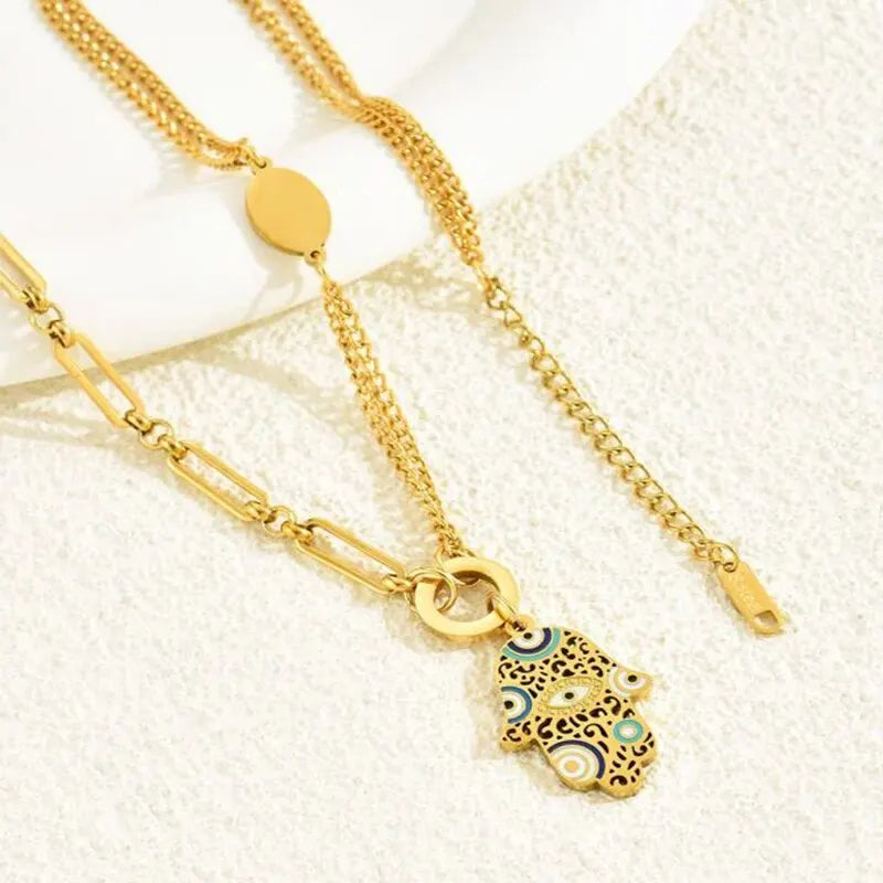 Descubra o Colar Mão De Fátima em Aço Inoxidável, com design Multicolorido e Dourado. Este Colar Feminino oferece Proteção e Estilo, sendo Resistente à Água, Durável e Hipoalergênico. Ideal para Festas e uso diário, combina Moda e Espiritualidade em uma peça única.