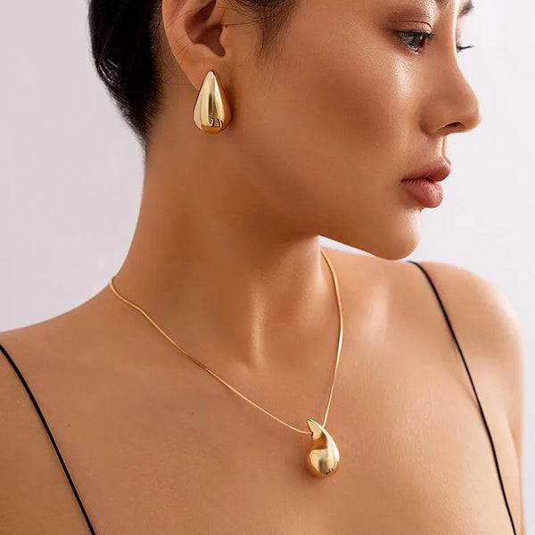 Descubra o Conjunto Gota Preciosa, perfeito para adicionar um toque de Elegância aos seus eventos. Este Conjunto Joias Vintage, incluindo Brincos Dourados e Colar Prateado, é ideal para destacar seu estilo em qualquer Festa. Elegante e atemporal, é a escolha certa para a mulher moderna.