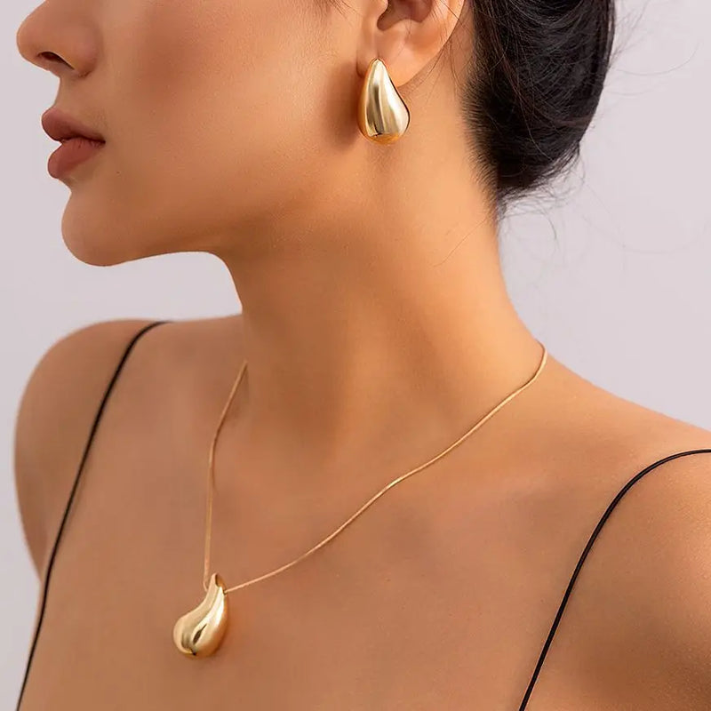 Descubra o Conjunto Gota Preciosa, perfeito para adicionar um toque de Elegância aos seus eventos. Este Conjunto Joias Vintage, incluindo Brincos Dourados e Colar Prateado, é ideal para destacar seu estilo em qualquer Festa. Elegante e atemporal, é a escolha certa para a mulher moderna.