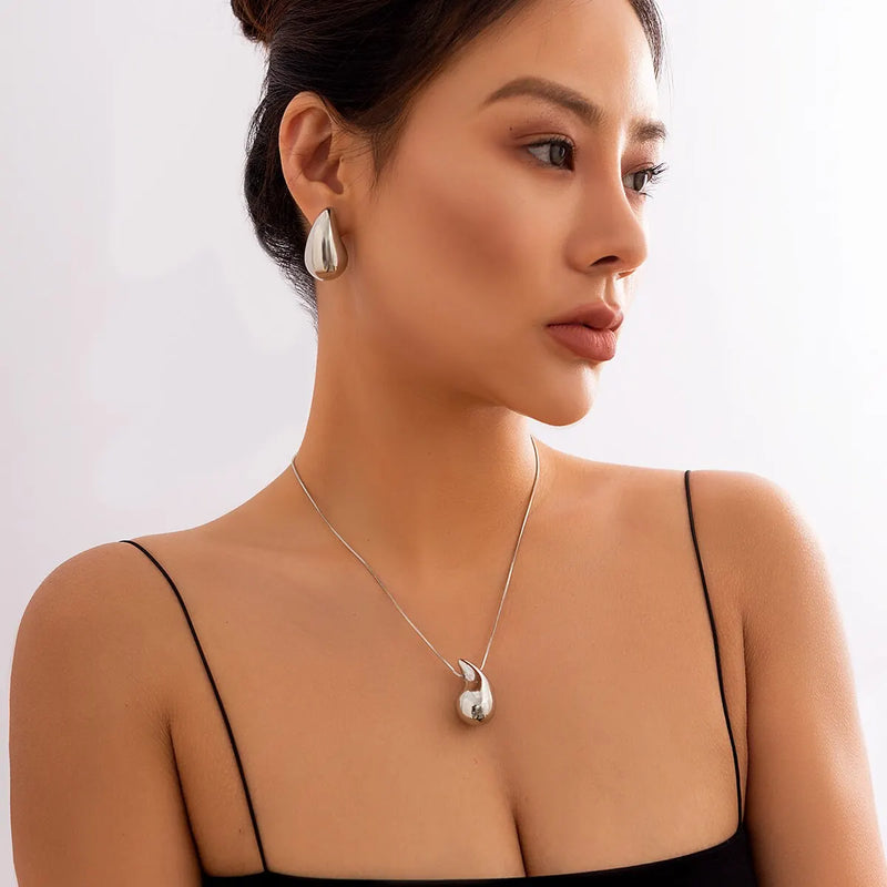 Descubra o Conjunto Gota Preciosa, perfeito para adicionar um toque de Elegância aos seus eventos. Este Conjunto Joias Vintage, incluindo Brincos Dourados e Colar Prateado, é ideal para destacar seu estilo em qualquer Festa. Elegante e atemporal, é a escolha certa para a mulher moderna.